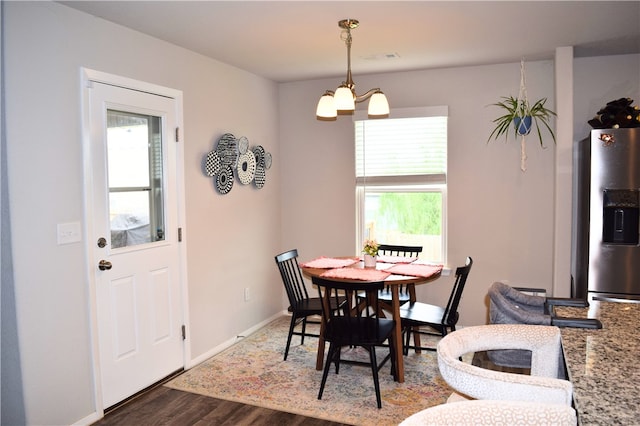 dining area featuring wood finished floors, a chandelier, and baseboards