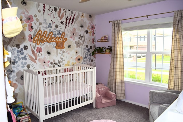 carpeted bedroom with baseboards and a crib