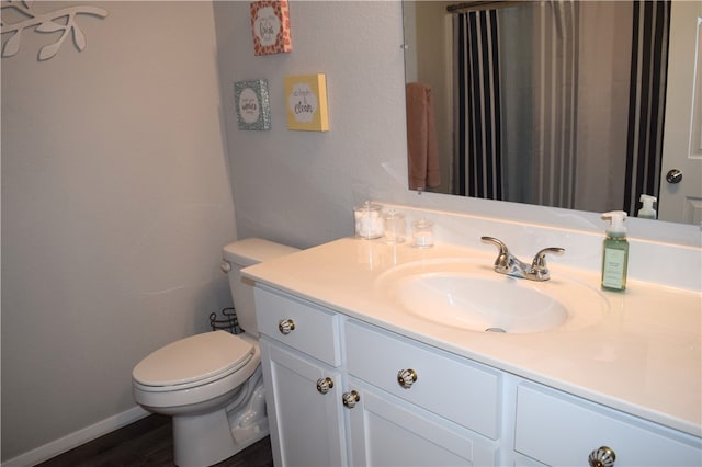 bathroom featuring toilet, vanity, and wood finished floors