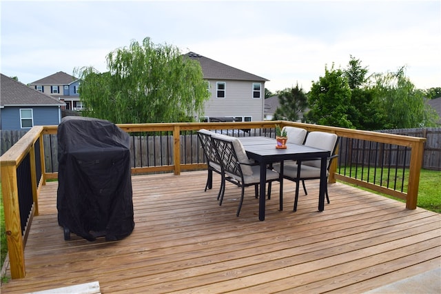 wooden deck with outdoor dining area and a fenced backyard