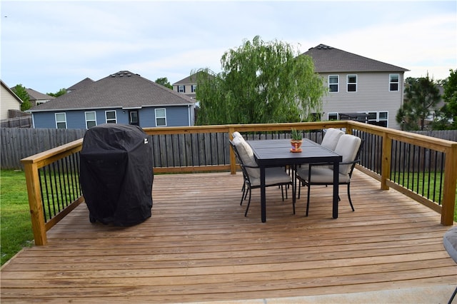 deck featuring outdoor dining area, grilling area, and fence