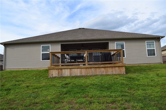 rear view of house with a wooden deck and a yard