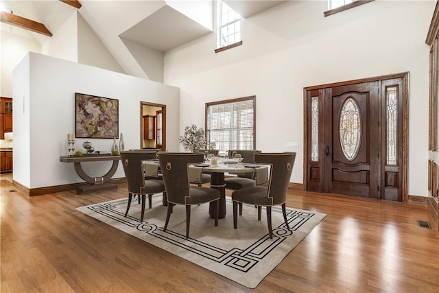 15533 Haynes Rd, Rogers, AR 72756 - dining room featuring plenty of natural light, a towering ceiling, wood finished floors, and baseboards