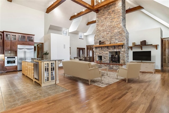15533 Haynes Rd, Rogers, AR 72756 - living room with high vaulted ceiling, beam ceiling, light wood-style flooring, and a stone fireplace