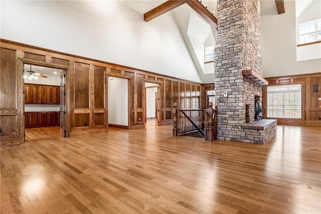 15533 Haynes Rd, Rogers, AR 72756 - unfurnished living room featuring high vaulted ceiling, healthy amount of natural light, light wood-type flooring, a ceiling fan, and a decorative wall