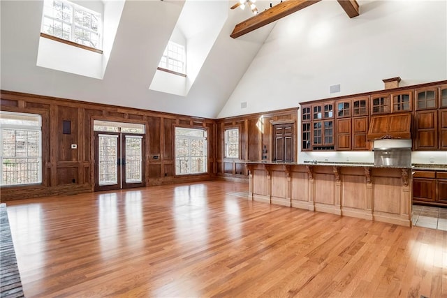 15533 Haynes Rd, Rogers, AR 72756 - kitchen with high vaulted ceiling, a breakfast bar, light wood-type flooring, healthy amount of natural light, and glass insert cabinets
