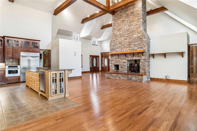 15533 Haynes Rd, Rogers, AR 72756 - kitchen with high vaulted ceiling, stainless steel appliances, open floor plan, beam ceiling, and baseboards