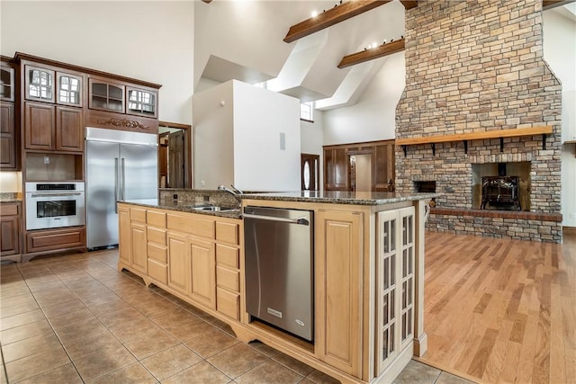 15533 Haynes Rd, Rogers, AR 72756 - kitchen with appliances with stainless steel finishes, high vaulted ceiling, beamed ceiling, dark stone countertops, and a sink