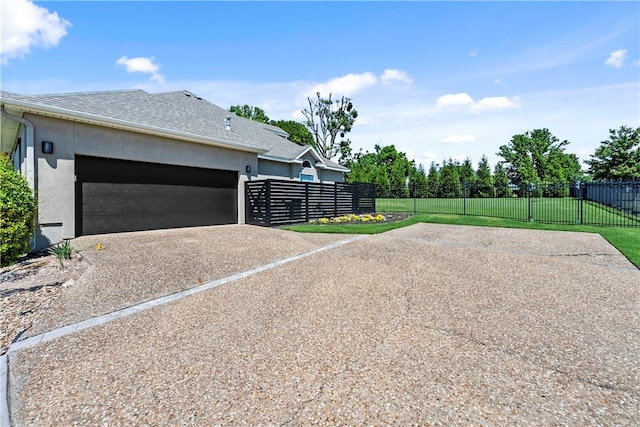view of property exterior featuring driveway, a garage, and stucco siding
