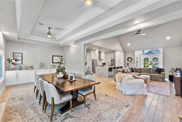 dining room with ceiling fan, recessed lighting, light wood finished floors, crown molding, and a raised ceiling