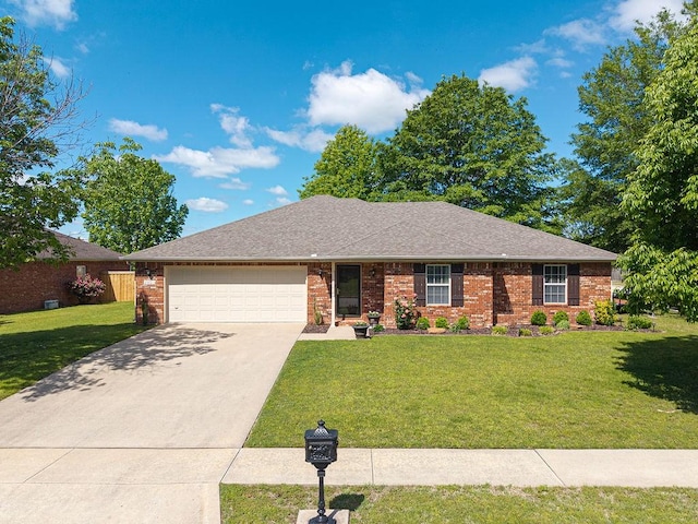 ranch-style home with an attached garage, driveway, a front yard, and brick siding