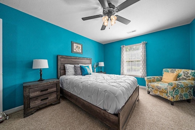 bedroom featuring carpet flooring, a ceiling fan, baseboards, and a textured ceiling