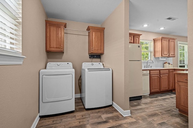 laundry area featuring washing machine and clothes dryer, dark wood finished floors, cabinet space, baseboards, and recessed lighting