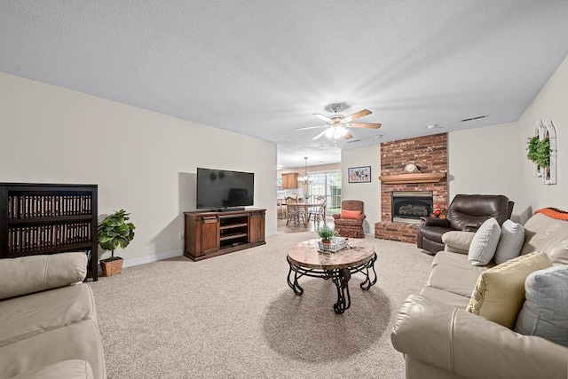 living room featuring a ceiling fan, carpet flooring, a brick fireplace, baseboards, and a textured ceiling