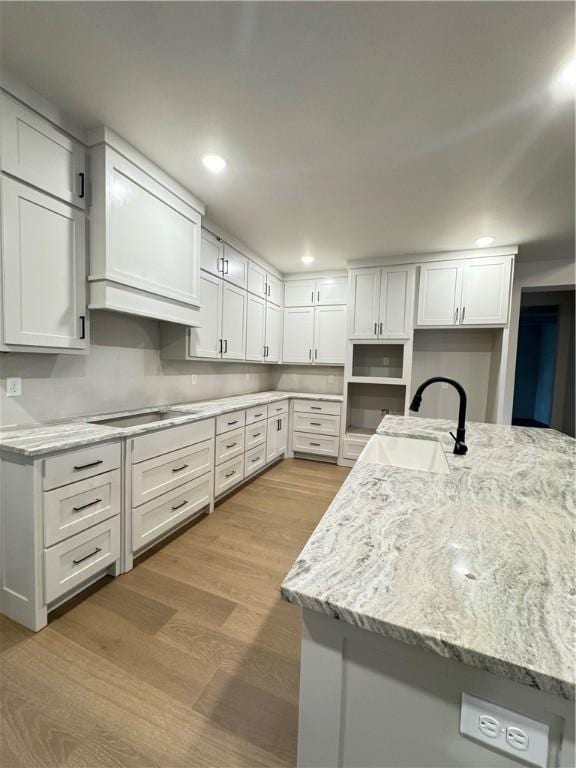 502 Concord St, Lowell, AR 72745 - kitchen with a sink, wood finished floors, black electric cooktop, white cabinetry, and recessed lighting