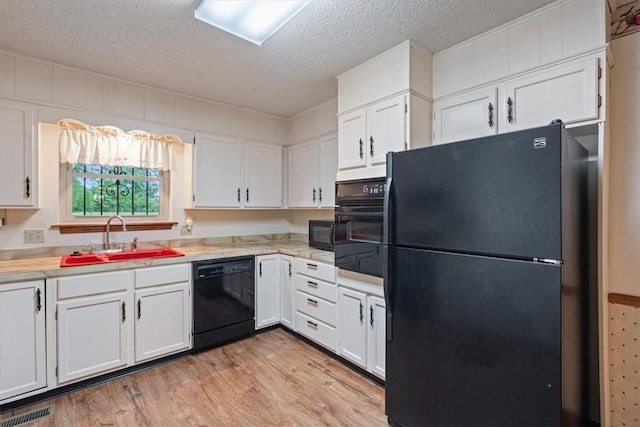 kitchen featuring black appliances, a sink, white cabinetry, and a textured ceiling