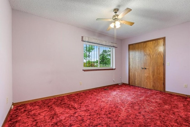 unfurnished bedroom featuring carpet, a textured ceiling, a closet, and baseboards