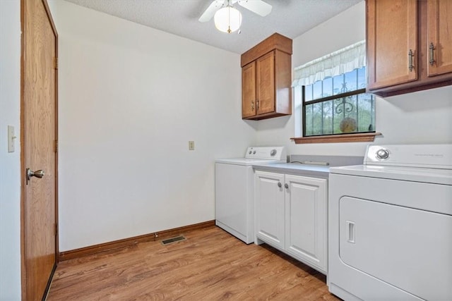 laundry room featuring washer and dryer, cabinet space, light wood-style flooring, a ceiling fan, and baseboards