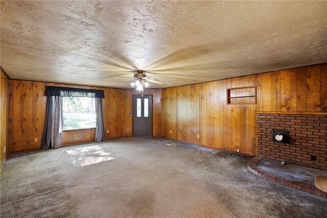10616 S Liberty Rd, Dardanelle, AR 72834 - unfurnished living room featuring carpet, a ceiling fan, wood walls, and a textured ceiling