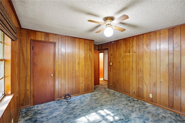 10616 S Liberty Rd, Dardanelle, AR 72834 - unfurnished bedroom with carpet, a textured ceiling, wooden walls, and a ceiling fan