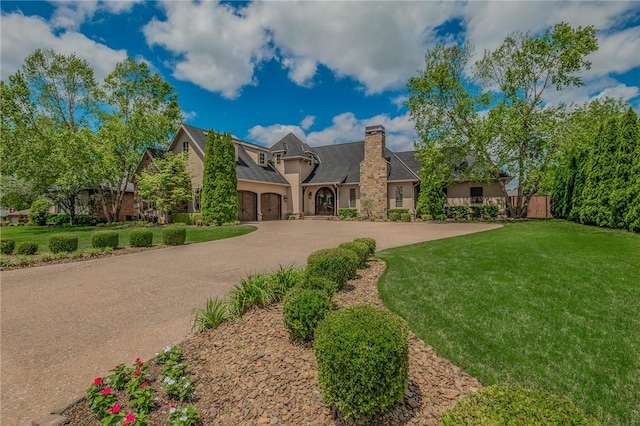 7 W Colonial Dr, Rogers, AR 72758 - view of front of property with a chimney, a front lawn, curved driveway, and an attached garage