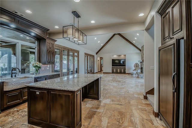 7 W Colonial Dr, Rogers, AR 72758 - kitchen with a sink, black refrigerator, a kitchen island, open floor plan, and stone tile floors