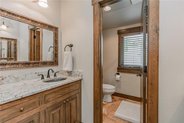 7 W Colonial Dr, Rogers, AR 72758 - bathroom with vanity, toilet, and stone finish floors