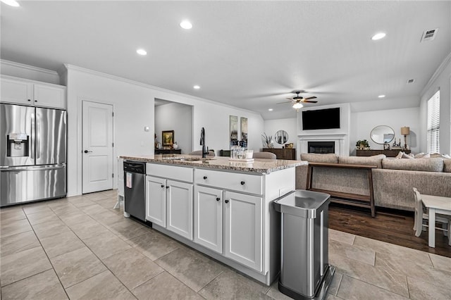 kitchen featuring appliances with stainless steel finishes, ceiling fan, ornamental molding, a kitchen island with sink, and recessed lighting