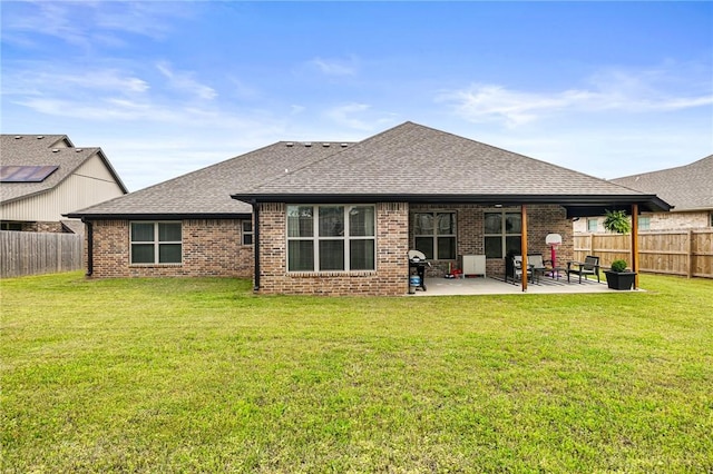 back of house with roof with shingles, a patio, and brick siding