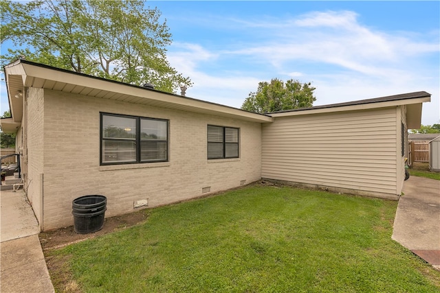 view of side of home with crawl space and brick siding