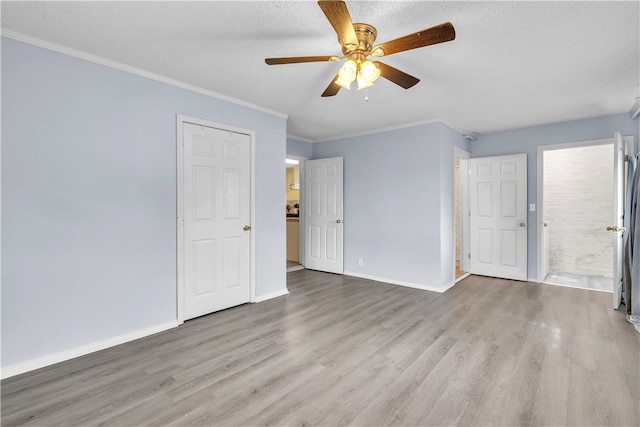 unfurnished living room with wood finished floors, a ceiling fan, baseboards, ornamental molding, and a textured ceiling