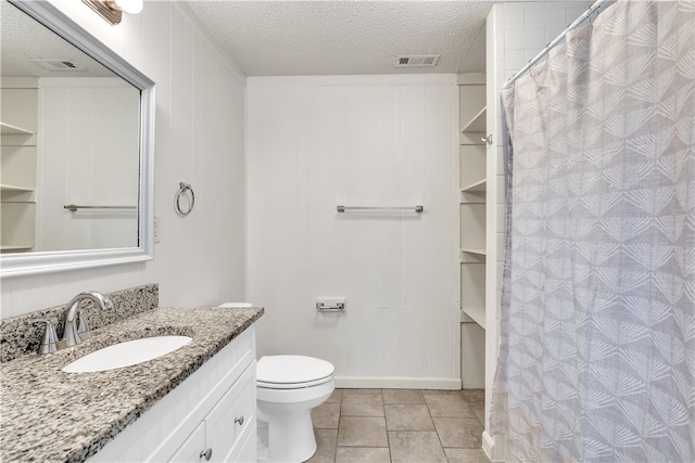 full bathroom featuring toilet, vanity, a textured ceiling, and a shower with shower curtain