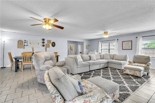 living area featuring ceiling fan, a textured ceiling, and tile patterned flooring