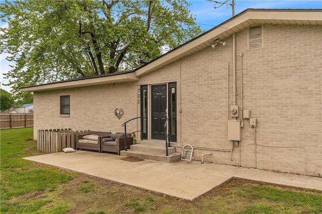 rear view of property with a patio and brick siding