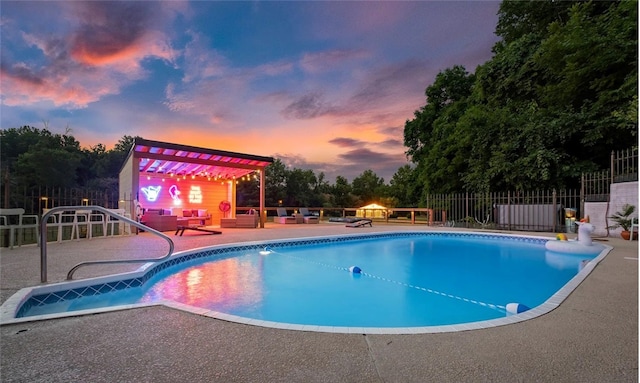 pool at dusk featuring an outdoor living space, a pergola, a patio area, and fence