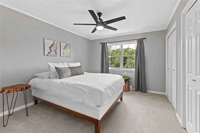 bedroom featuring ornamental molding, light carpet, baseboards, a textured ceiling, and a ceiling fan