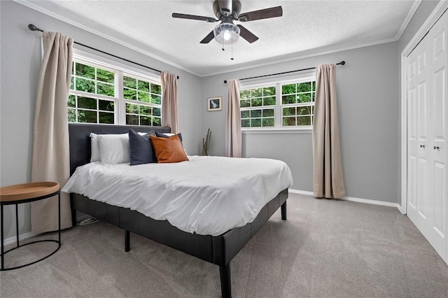 bedroom with multiple windows, ornamental molding, carpet floors, a textured ceiling, and a closet