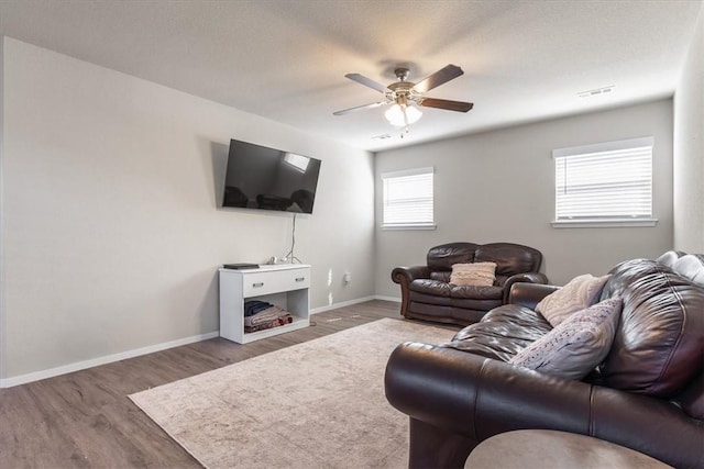 living room with a ceiling fan, wood finished floors, and baseboards