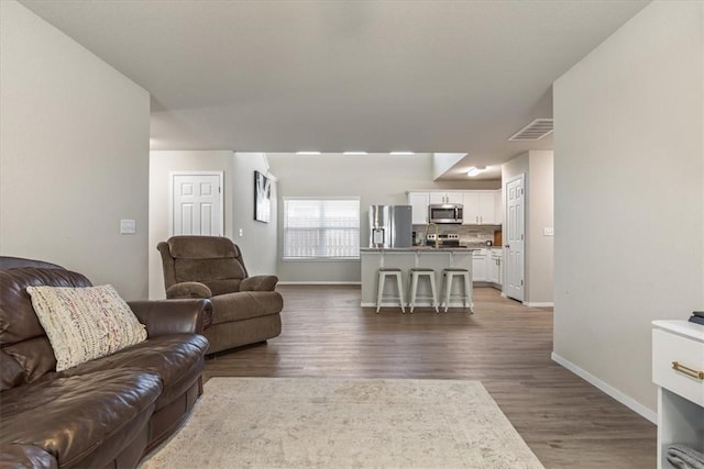 living room with baseboards and wood finished floors