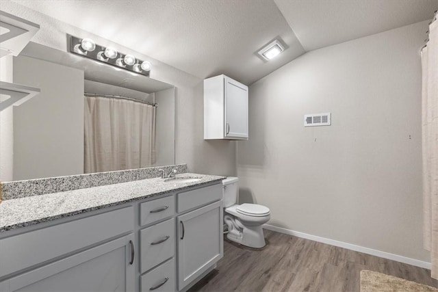 full bath featuring wood finished floors, vaulted ceiling, toilet, baseboards, and vanity