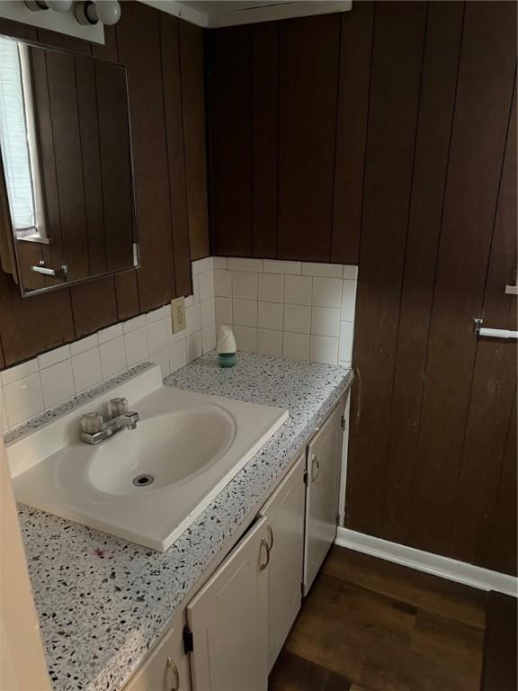 bathroom with wood finished floors, decorative backsplash, and vanity