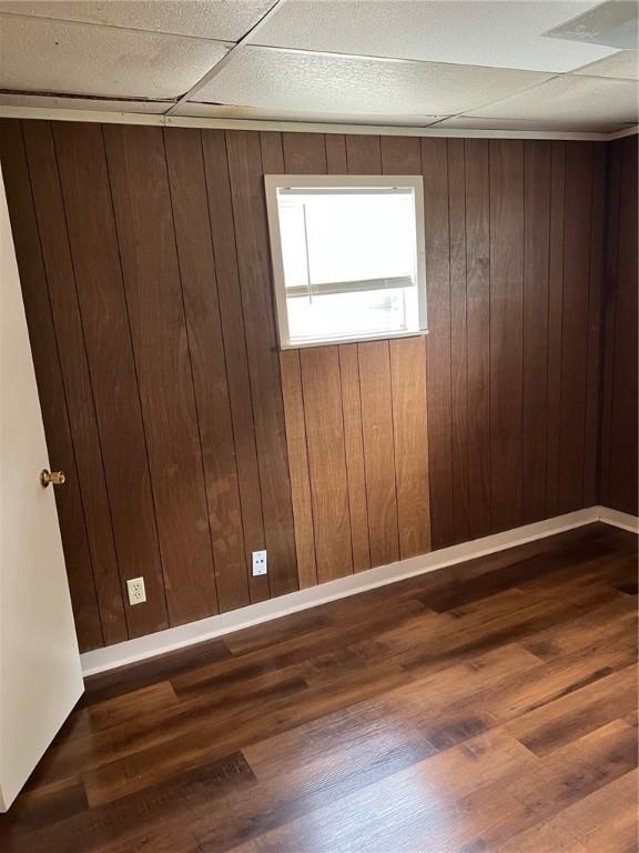 spare room with wood finished floors and wooden walls