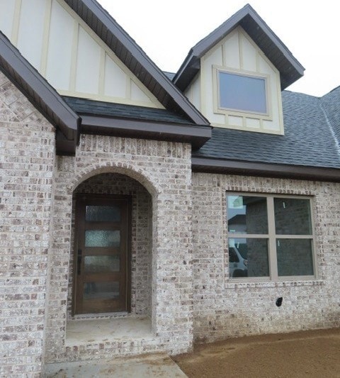 1214 Carrara St, Tontitown, AR 72762 - view of exterior entry with brick siding and roof with shingles