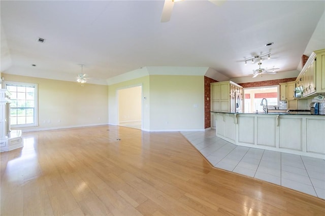 307 E Edmondson Ave, Springdale, AR 72764 - unfurnished living room featuring ceiling fan, light wood-style flooring, and plenty of natural light