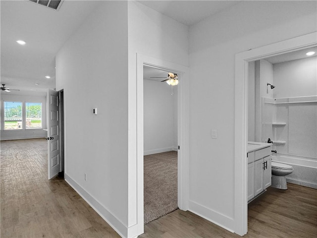 hallway with wood finished floors, recessed lighting, and baseboards