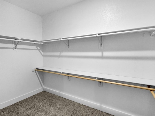 spacious closet featuring dark carpet