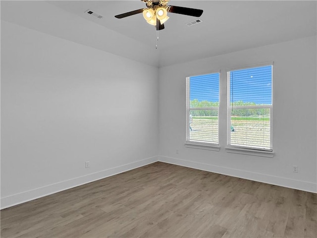 unfurnished room with wood finished floors, baseboards, and a ceiling fan