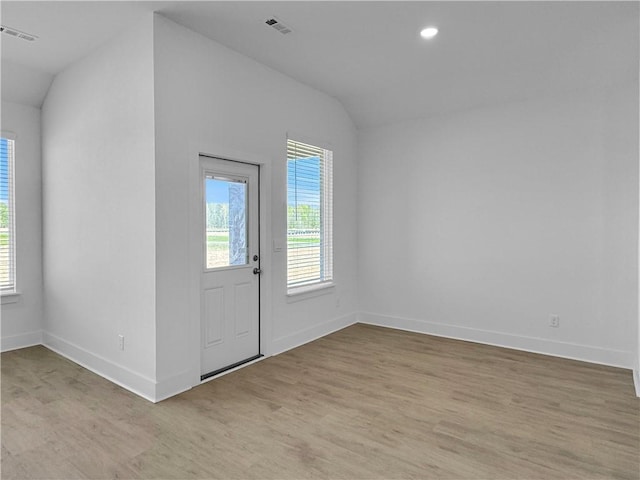 entryway featuring lofted ceiling, plenty of natural light, light wood-style floors, baseboards, and recessed lighting
