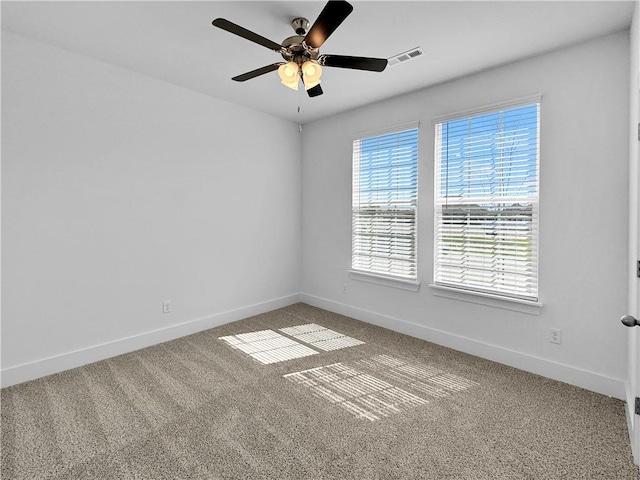 carpeted empty room with a ceiling fan and baseboards