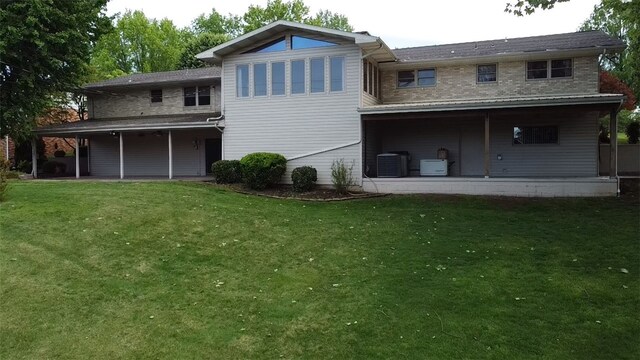 back of property featuring a patio area, a yard, and central AC